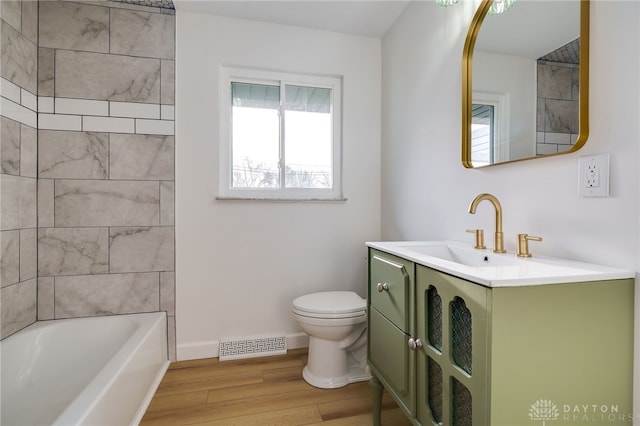 full bathroom featuring toilet, wood finished floors, vanity, visible vents, and baseboards