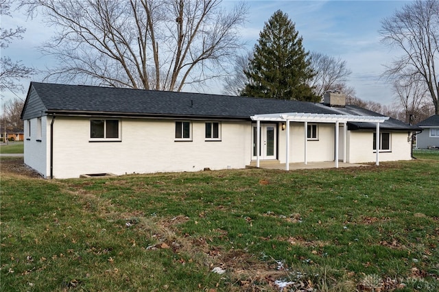 view of front facade with brick siding, a pergola, a front lawn, a chimney, and a patio area