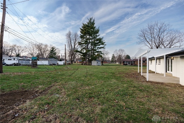 view of yard featuring a storage shed, a patio, an outbuilding, a playground, and a pergola