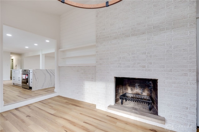 interior space with light wood-type flooring, a fireplace, and recessed lighting