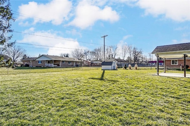 view of yard with an outbuilding, a fenced backyard, a residential view, and a shed