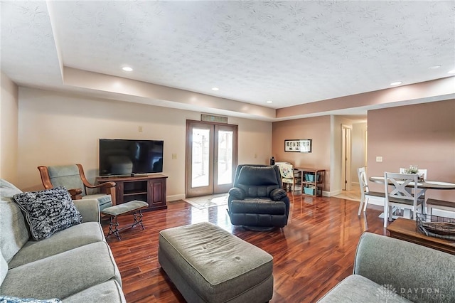 living room featuring baseboards, dark wood-type flooring, a textured ceiling, french doors, and recessed lighting