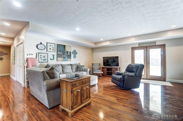 living room with a textured ceiling, recessed lighting, baseboards, french doors, and dark wood finished floors