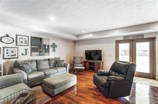 living room with recessed lighting, a textured ceiling, hardwood / wood-style floors, and french doors