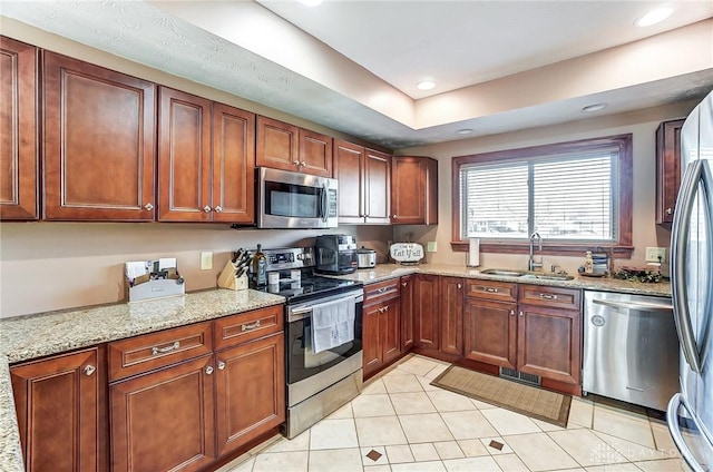 kitchen featuring visible vents, appliances with stainless steel finishes, light stone counters, a sink, and recessed lighting