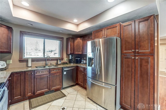 kitchen with light tile patterned floors, a sink, visible vents, appliances with stainless steel finishes, and light stone countertops