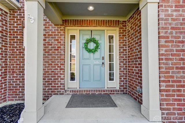 view of exterior entry featuring brick siding