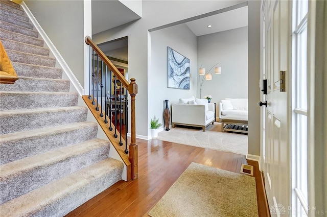 stairs with recessed lighting, wood finished floors, visible vents, and baseboards