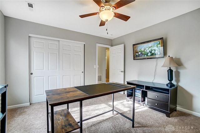 office space with light carpet, ceiling fan, visible vents, and baseboards