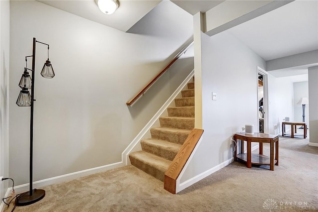 staircase featuring carpet and baseboards