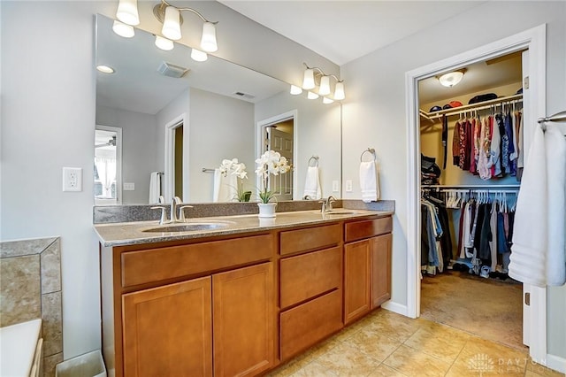 bathroom with visible vents, a sink, and double vanity