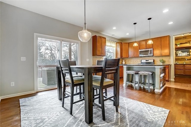 dining space with light wood-type flooring, baseboards, and recessed lighting