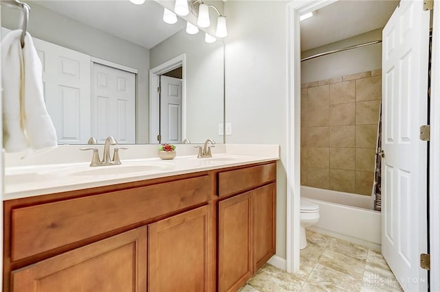 bathroom with double vanity, shower / bath combo, a sink, and toilet