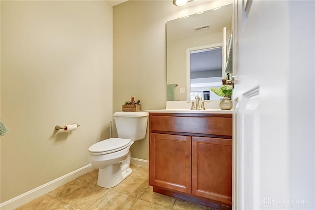 bathroom featuring visible vents, toilet, vanity, tile patterned flooring, and baseboards