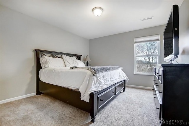 bedroom with baseboards, visible vents, and light colored carpet