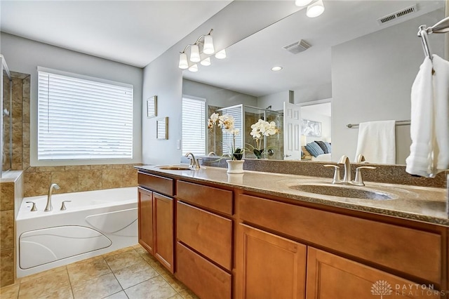 ensuite bathroom with double vanity, tile patterned flooring, a sink, and visible vents