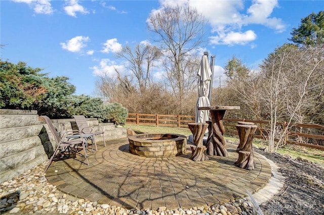 view of patio / terrace with an outdoor fire pit and fence