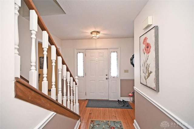 foyer featuring light wood finished floors and stairway