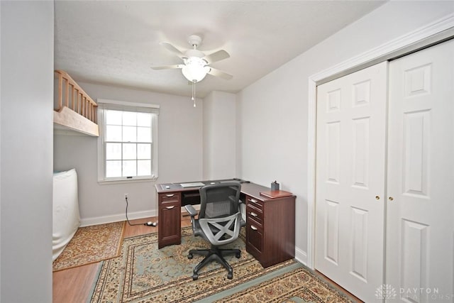 office space with ceiling fan, baseboards, and wood finished floors