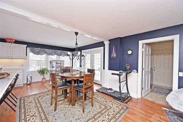 dining space featuring a wealth of natural light, wainscoting, and light wood-style flooring