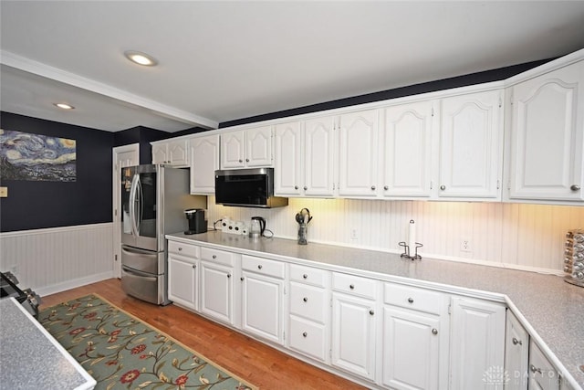 kitchen featuring light countertops, appliances with stainless steel finishes, white cabinetry, and light wood-style floors