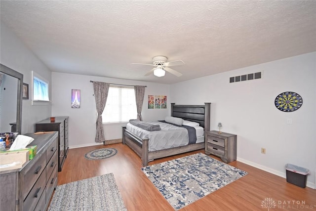 bedroom with light wood-style flooring, visible vents, and baseboards