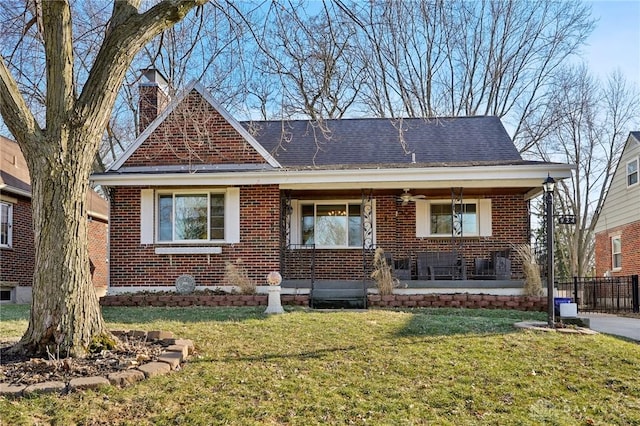 view of front of property featuring brick siding, a front lawn, and a chimney