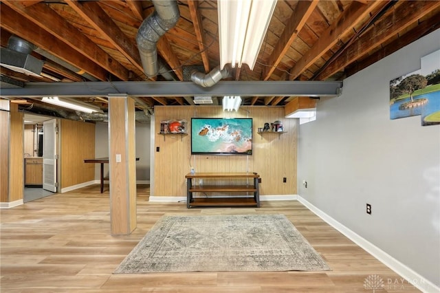 finished basement with wood walls, wood finished floors, and baseboards