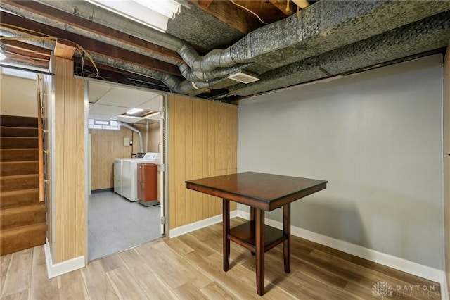 unfinished below grade area with stairway, washer and clothes dryer, wood finished floors, and baseboards