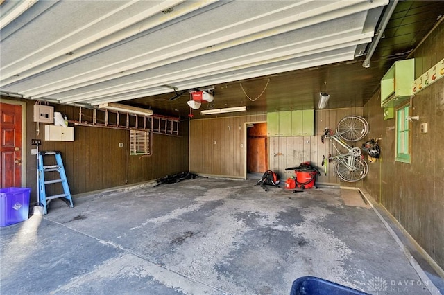 garage featuring wood walls and a garage door opener