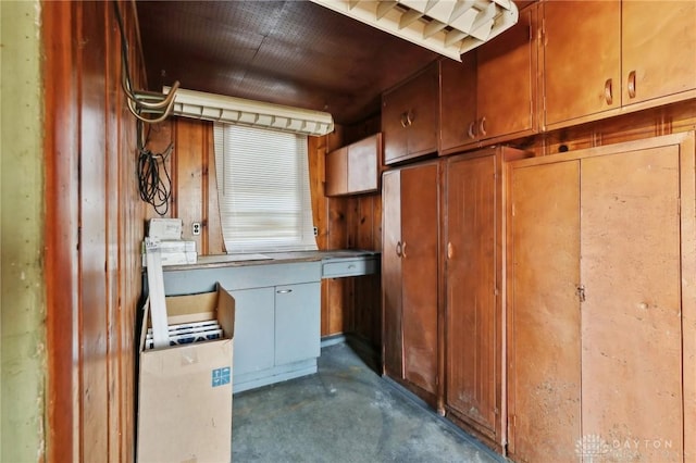 kitchen with brown cabinetry and unfinished concrete floors