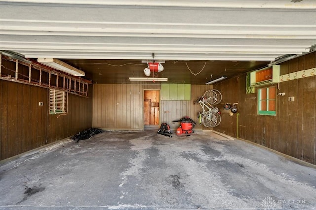 garage with wooden walls and a garage door opener