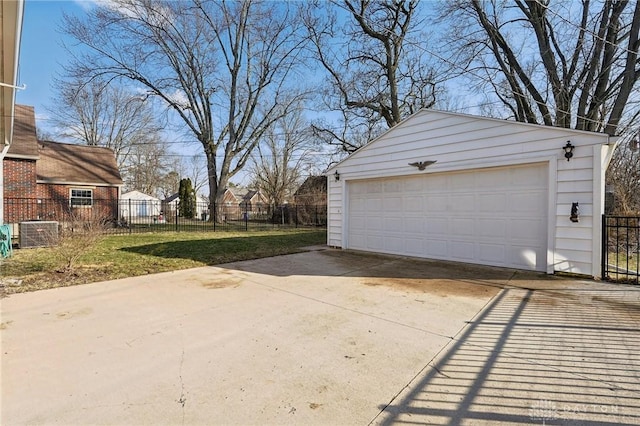 detached garage featuring fence and cooling unit