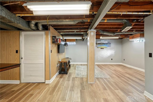 below grade area with plenty of natural light, baseboards, and wood finished floors