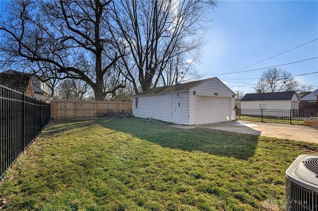 view of yard featuring a garage, central air condition unit, a fenced backyard, and an outbuilding