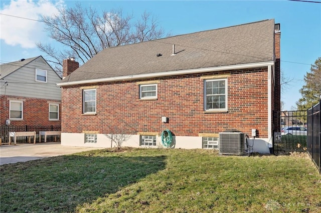 rear view of property featuring fence, a yard, central air condition unit, a patio area, and brick siding