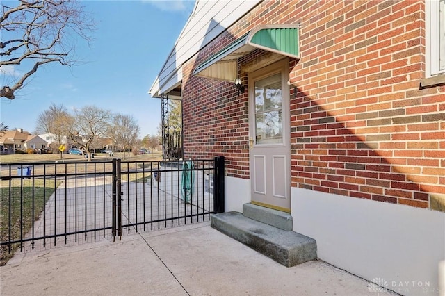 entrance to property with brick siding and fence