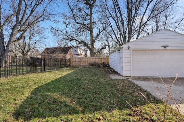 view of yard featuring a detached garage, fence, and an outbuilding