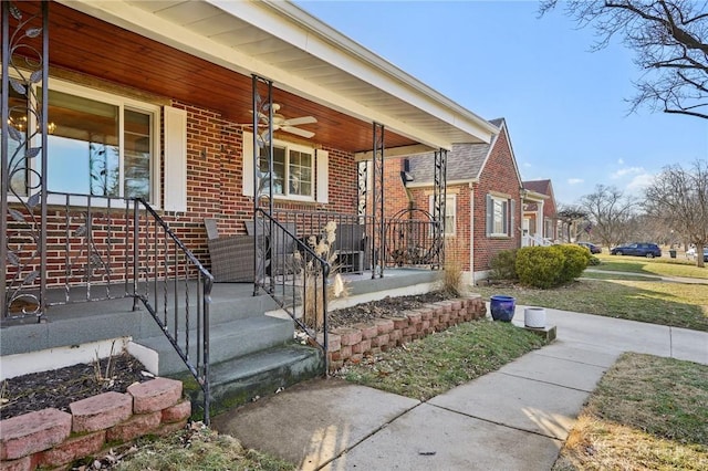 view of exterior entry with covered porch and brick siding