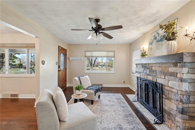 living room featuring dark wood-style floors, a wealth of natural light, and visible vents