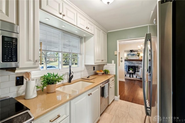 kitchen with stainless steel appliances, light countertops, and white cabinetry