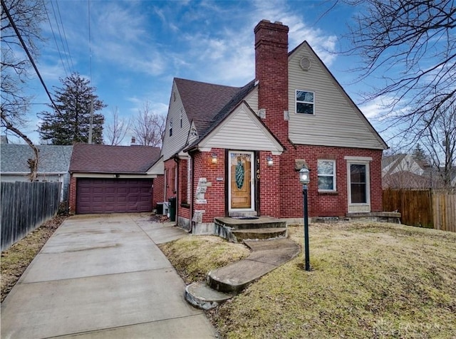 view of front of property with a garage, brick siding, fence, and a chimney