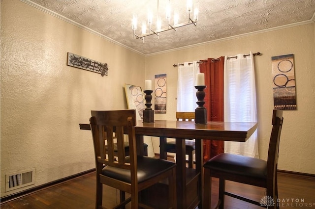 dining area with ornamental molding, visible vents, a notable chandelier, and wood finished floors