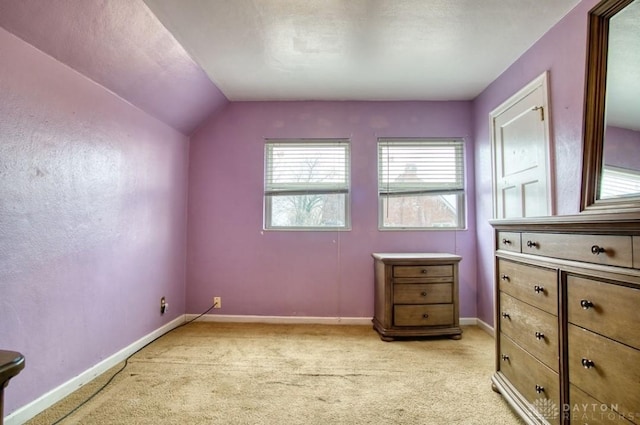 additional living space with light carpet, vaulted ceiling, and baseboards