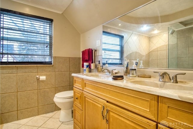 full bathroom featuring tiled shower, a sink, tile walls, and tile patterned floors