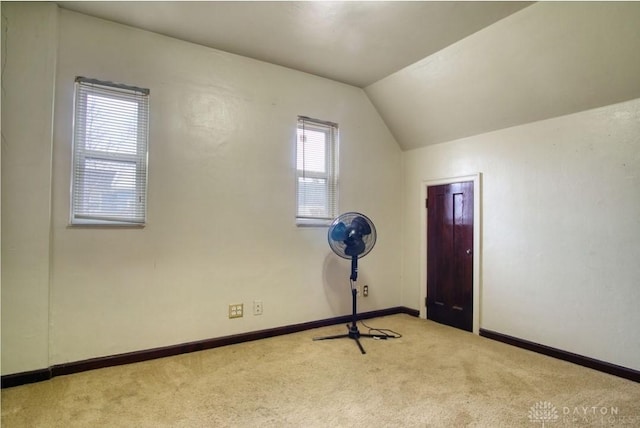 additional living space featuring vaulted ceiling, carpet floors, and baseboards