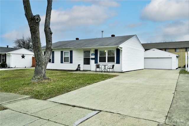 single story home featuring a garage, a front lawn, and an outbuilding