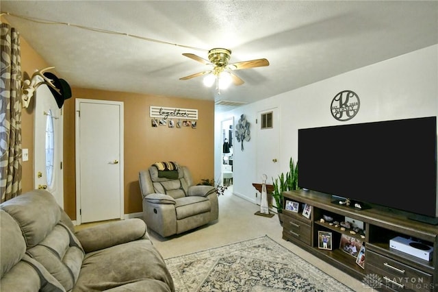 living area with light carpet, ceiling fan, visible vents, and baseboards