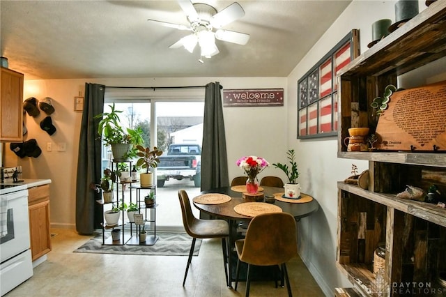 dining room with a ceiling fan and baseboards