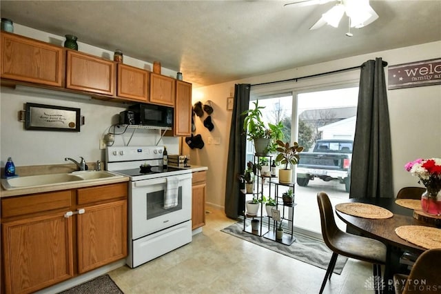 kitchen featuring black microwave, a sink, light countertops, brown cabinetry, and white range with electric cooktop